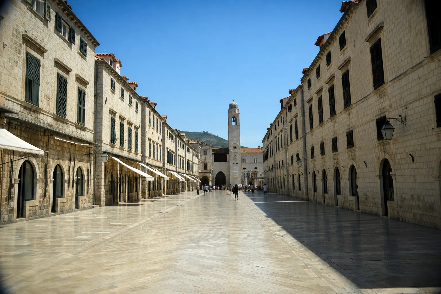 Stradun u Dubrovniku sa zvonikom na kraju ulice po sunčanom danu
