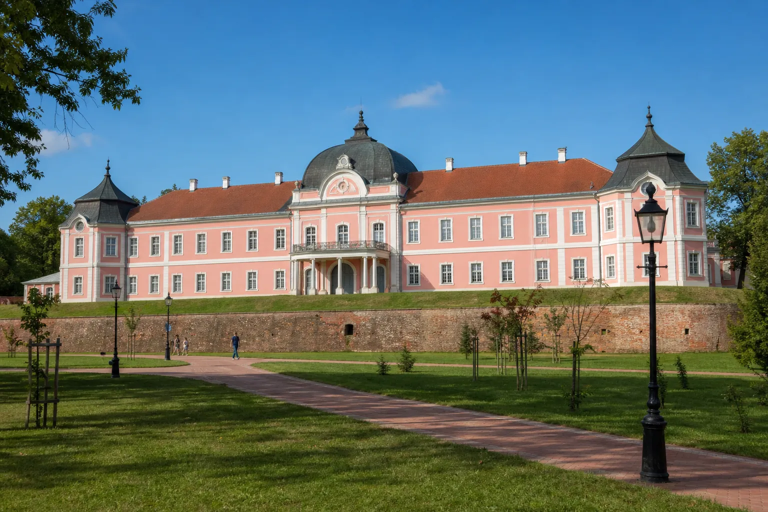 Dvorac Pejačević u Virovitici s ružičastim pročeljem i tamnom kupolom po sunčanom danu